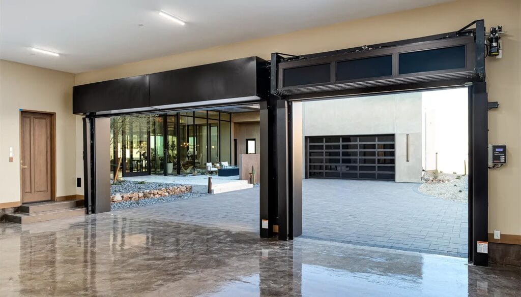 Interior view of a luxury garage with polished concrete floors and modern aluminum-and-glass garage doors — an example of what an upgrade can look like when it’s time to replace your garage door.
