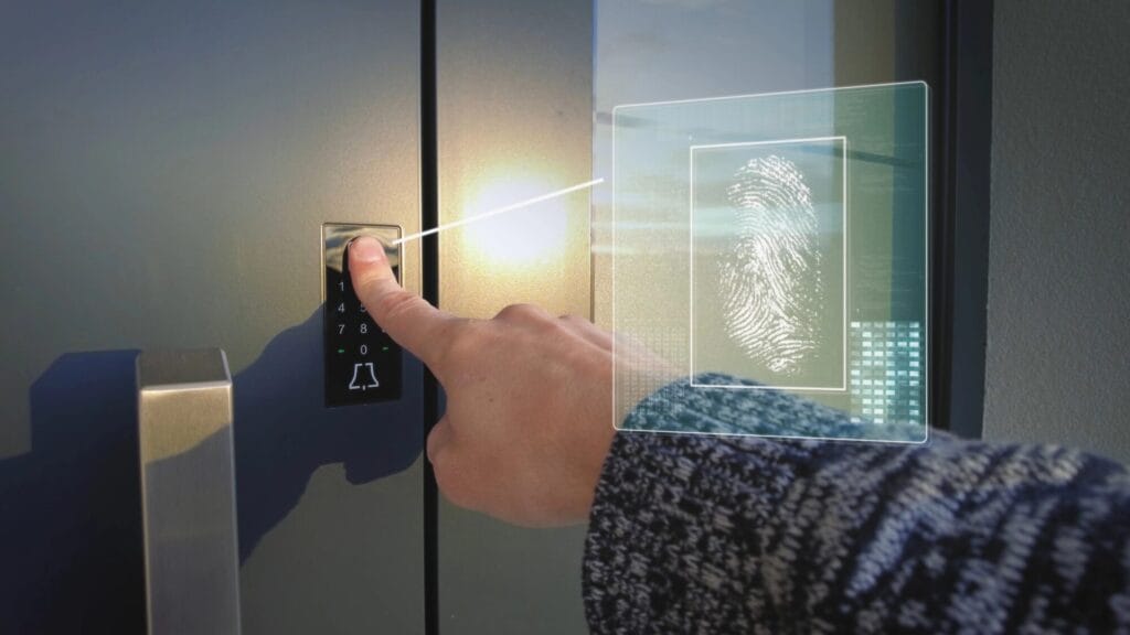 A hand interacts with a keyless entry smart lock, featuring a keypad and a futuristic digital overlay of a fingerprint, representing one of the advanced types of door locks with remote access capabilities.