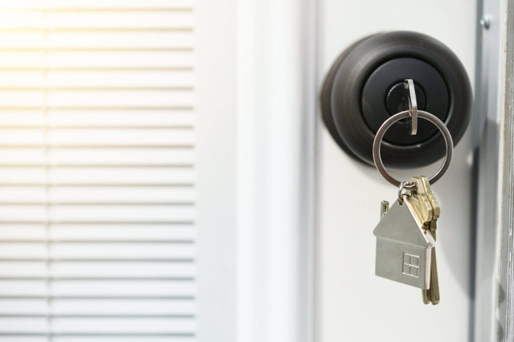 A polished brass keyed entry doorknob isolated on a white background.