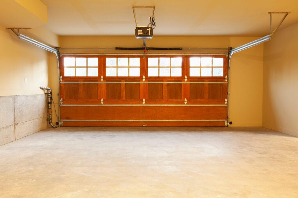 The interior view of a wooden garage door and its metal track system, components that often require lubrication to prevent a squeaky garage door.